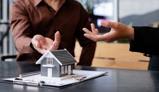 people talking and pointing at model of house